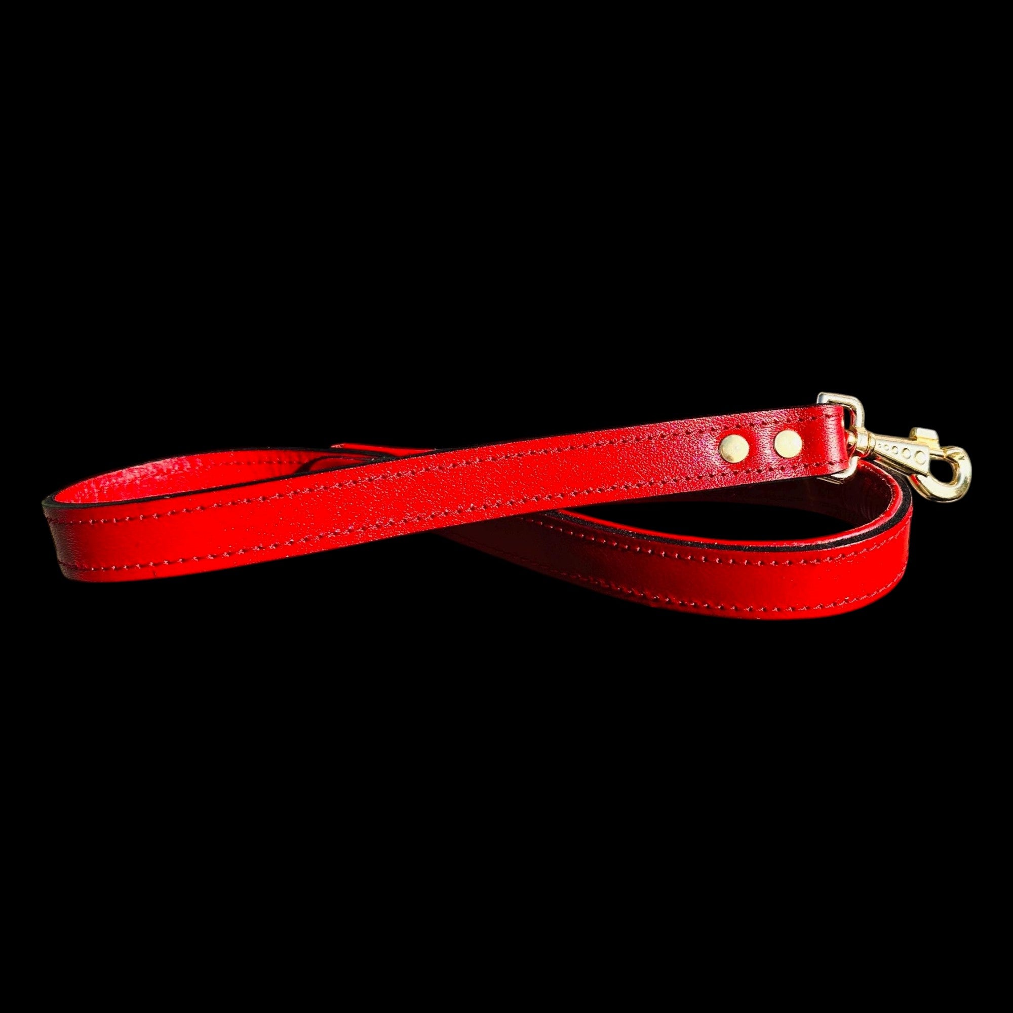 A&C Dog Collars red buffalo leather dog leash with gold-tone hardware and hand-riveted details on black background