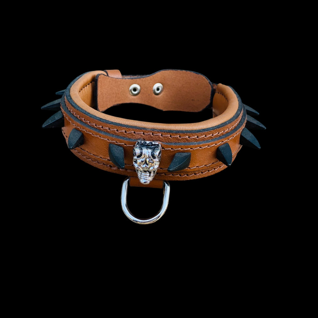 Close-up of Bully logo centerpiece and black protective spikes on handmade brown leather dog collar.